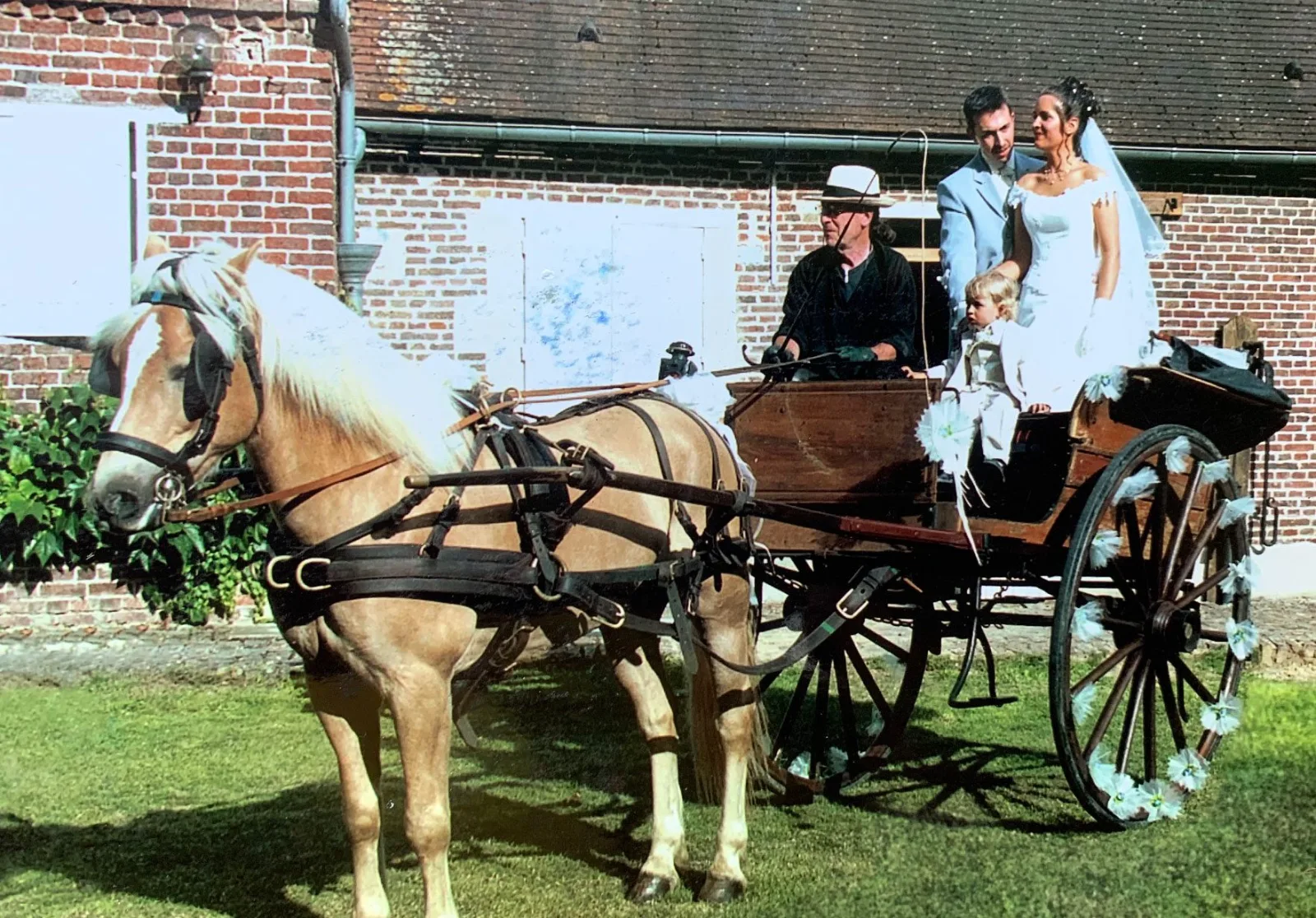 Les mariés et leur enfant dans une calèche fleurie