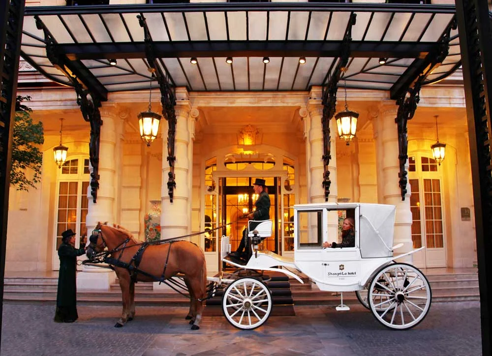 Calèche blanche du Shangri-La sous la marquise de l'hôtel, cocher en haut-de-forme